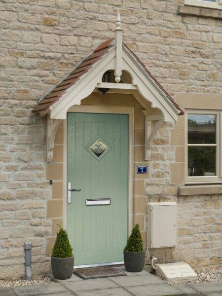 A Donaldson Doors external door in a residential development, showing a wooden door with a small ornate entrance roof.